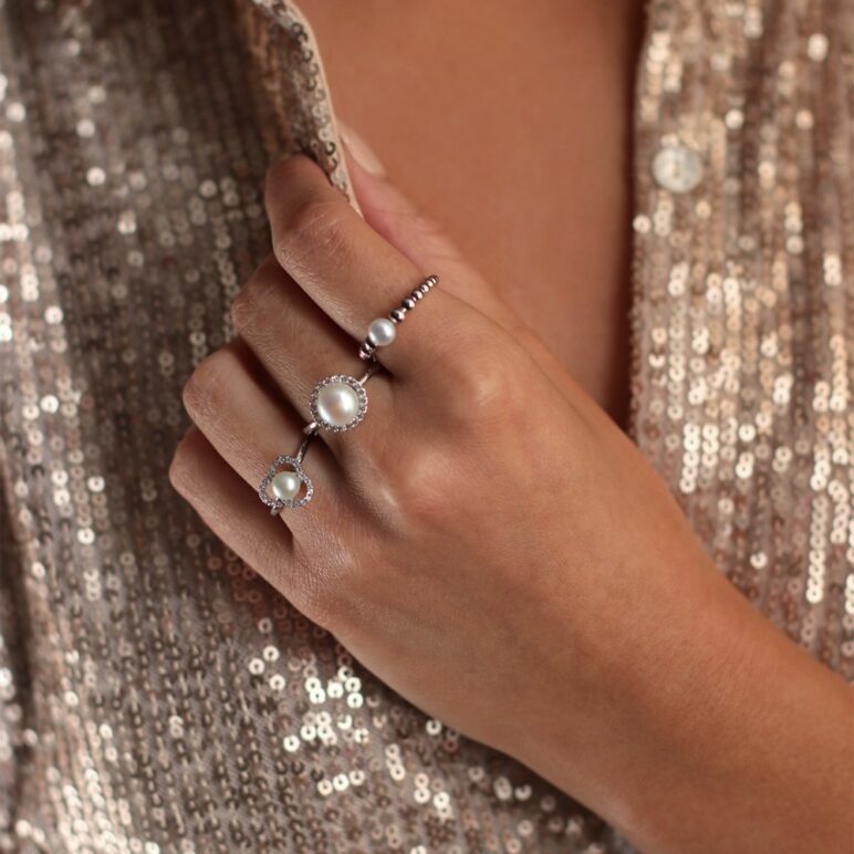 A Lady wearing 3 Jersey Pearl Rings, one being from their Amberley collection featuring a freshwater pearl, white topaz on rhodium plated sterling silver