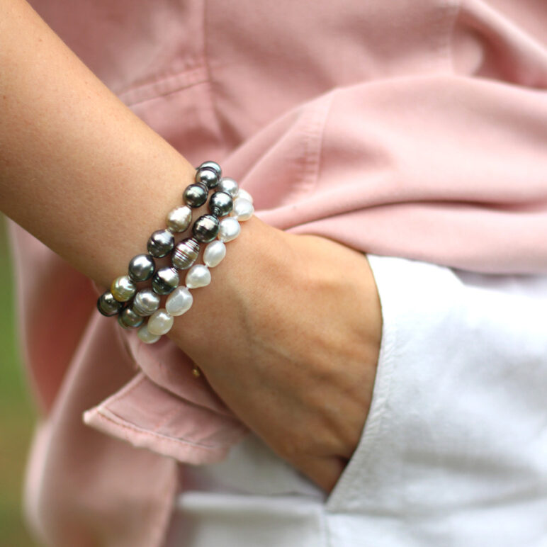 A lifestyle product image, featuring a woman wearing stacked Zara Tahitian pearl bracelets