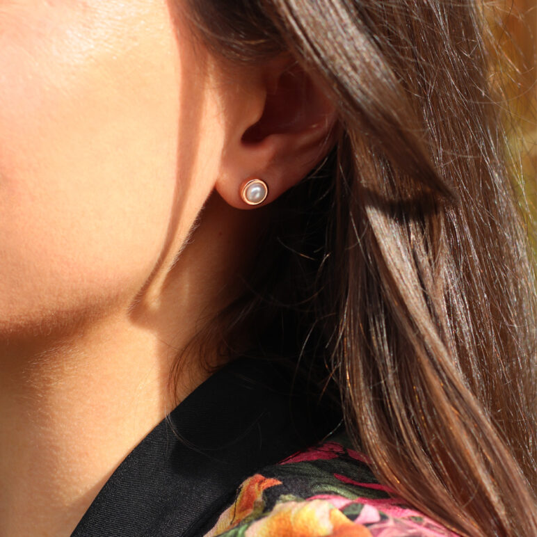 Model wearing Jersey Pearl Alice Rose Gold Small Stud Earrings. White Freshwater Button Pearls set in Sterling Silver with Rose Gold Plating