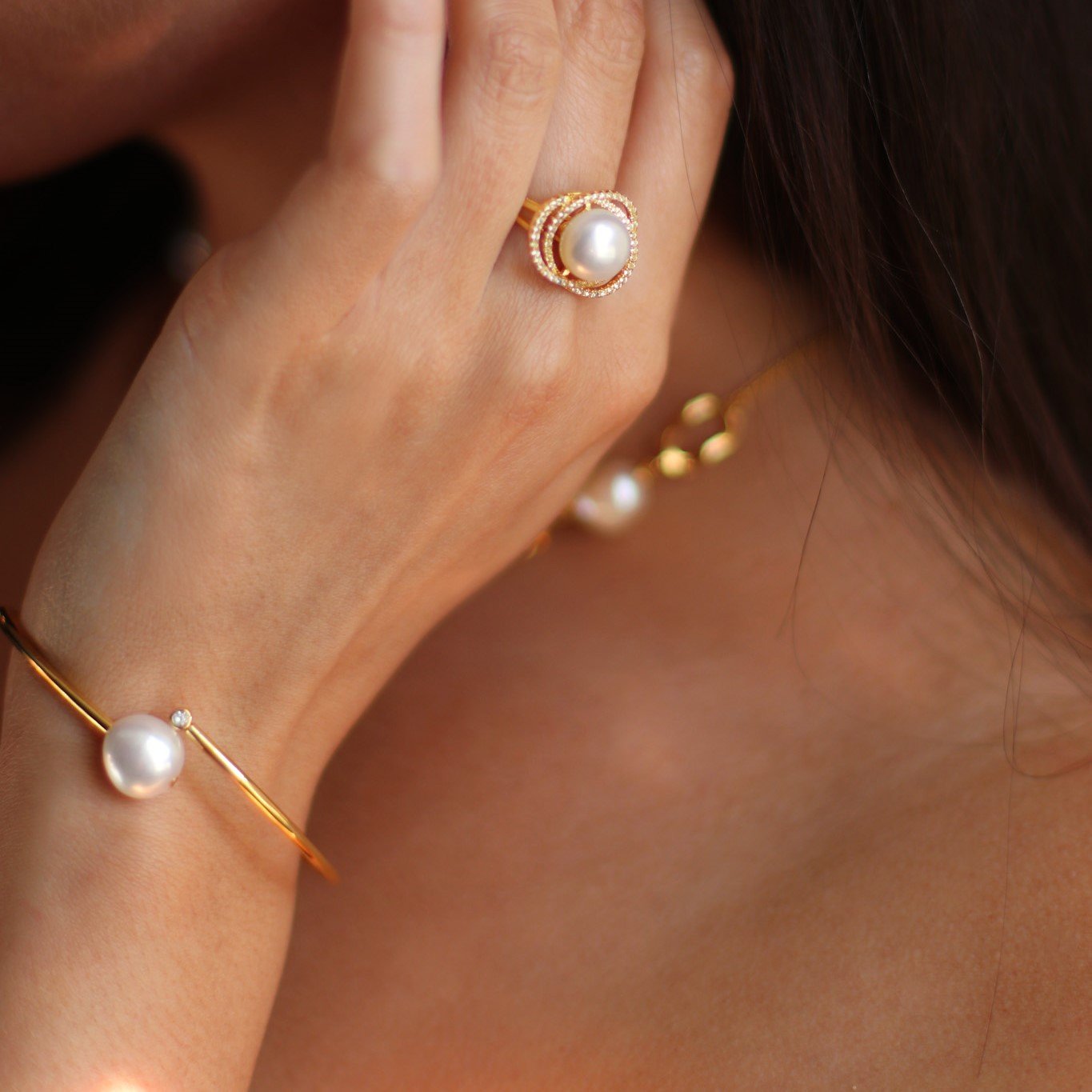 model wearing marette sparkly pearl ring and a gold baroque pearl bracelet