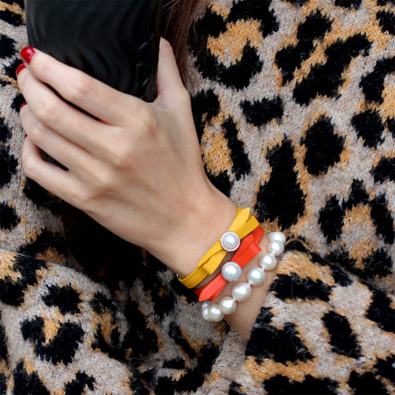 Model wearing Edison Pearl Zara bracelet with yellow and coral coloured Joli bracelets