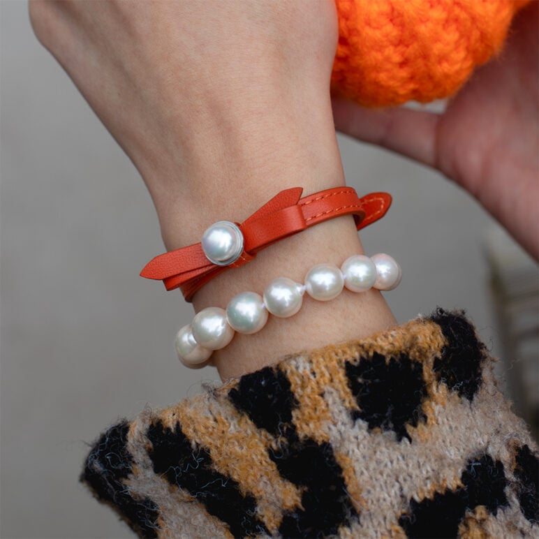 Model wearing Coral Joli bracelet with Zara Edison White Pearl bracelet