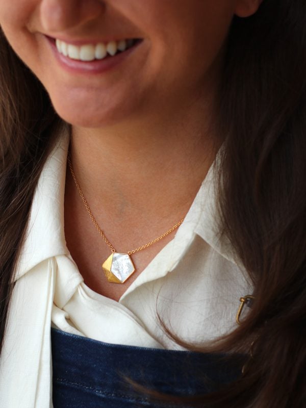 Lifestyle model wearing Kyra gold pendant