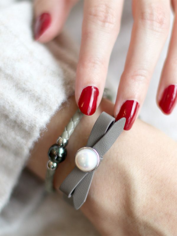 Grey Joli bracelet and Tahitian pearl bracelet stacked on models arm