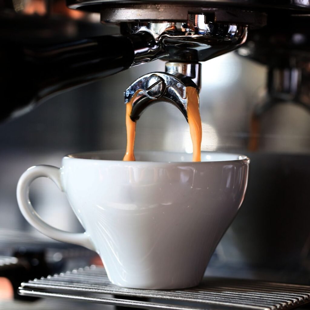 photo of coffee pouring into a coffee cup from the coffee machine